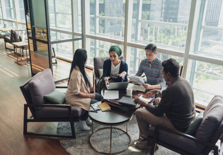 A diverse team discussing in a meeting displaying talent development and investing in people within the organization.