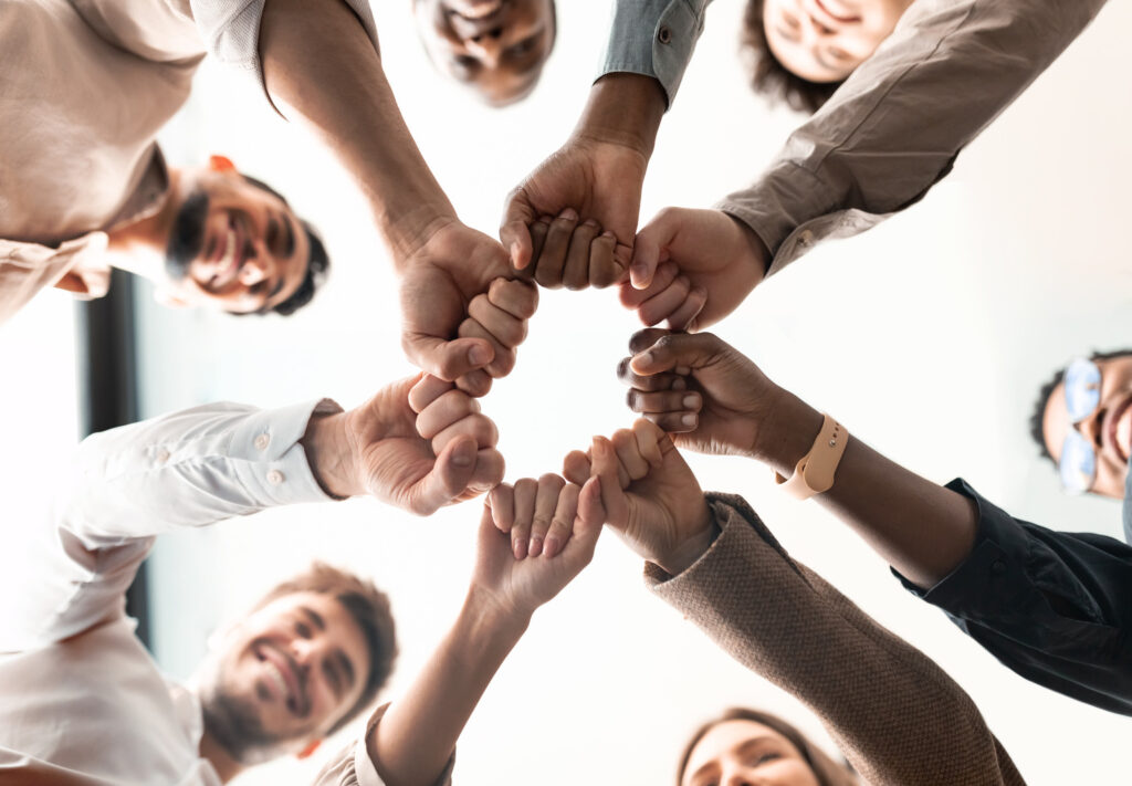 Team fist bump in a circle showing commitment to a culture transformation