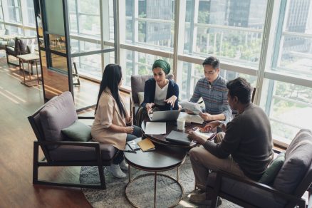 A diverse team discussing in a meeting displaying talent development and investing in people within the organization.